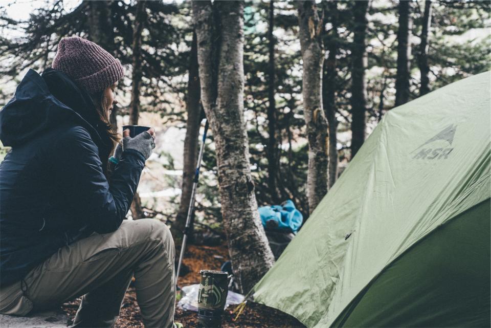 girl drinking coffee in woods